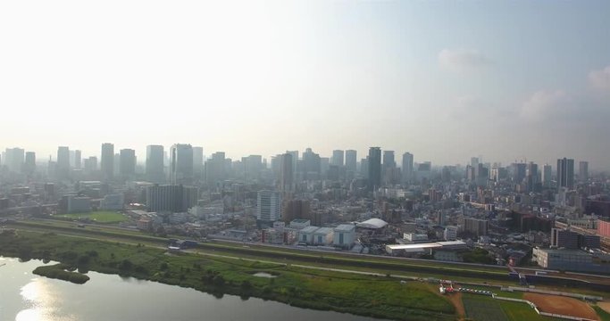 Revealing shot of Osaka City Skyline large metropolitan area aerial shot. 