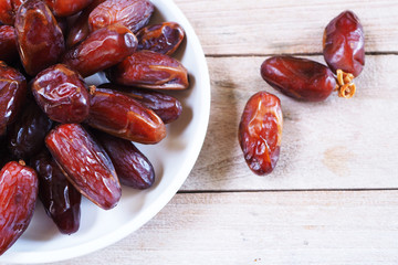 Top view of pile of dried date fruit on a wooden table.