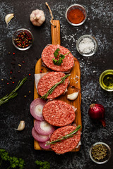 Raw ground beef meat steak cutlets with herbs and spices.