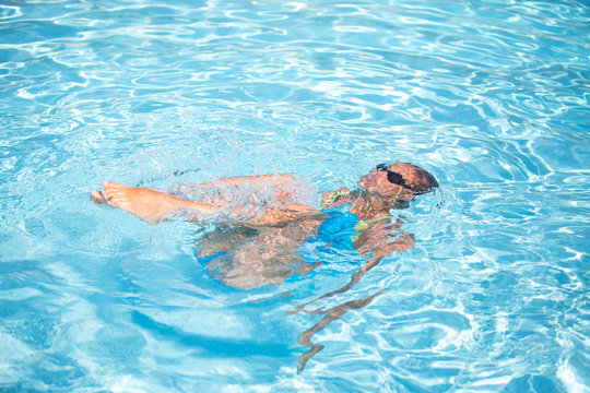 Young woman in a swimming pool performing some synchronized swim