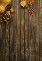 Kitchen table with pumpkin and spices. Space for text