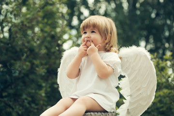 Little smiling boy dressed as angel