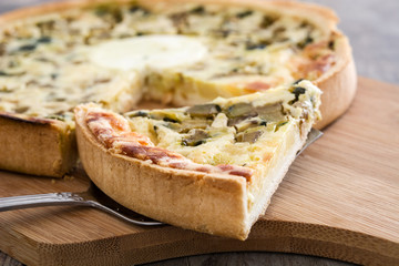 French quiche with vegetables on a rustic wooden table

