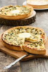 French quiche with vegetables on a rustic wooden table

