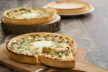French quiche with vegetables on a rustic wooden table

