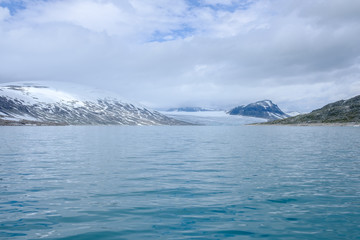 Scenic view of Styggevatnet with snowy mountains on the background.