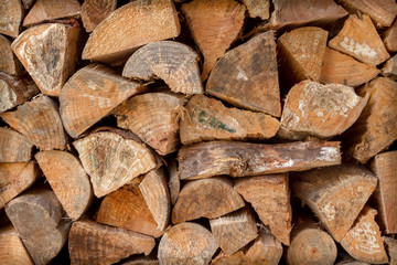 pile of chopped fire wood stacked against a wall