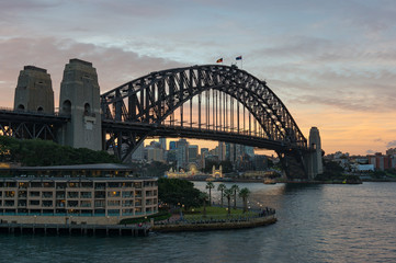 Fototapeta na wymiar Circular Quay and Harbour Bridge with view of North Sydney and sunset sky on the background