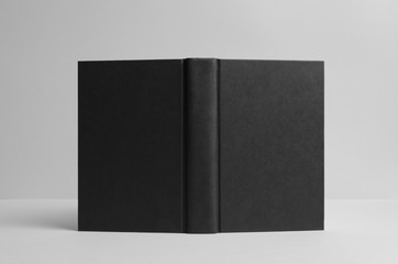 Black Hardcover Book Mock-Up - Opened Outside. Wall Background