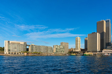 Modern skyscrapers with railway, train station and ferry wharfs against blue sky on the background. Circular Quay, Sydney, Australia