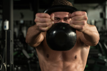 Fototapeta na wymiar Fitness Man Using Kettlebells Inside Gym