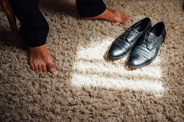 Close-up young man tying elegant shoes indoors