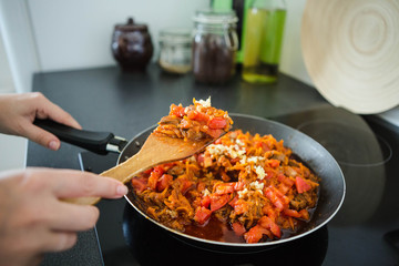 Woman fry the onion, carrots and garlic in a pan. Preparation for Lagman soup, borscht, saltwort. Homemade food.