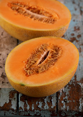 Ripe melon cut in half on a wooden table