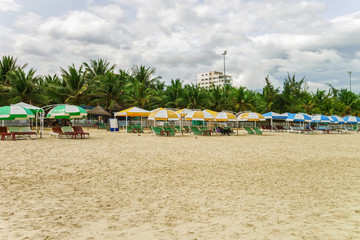 Fototapeta na wymiar Palm shelters and people at China Beach in Danang