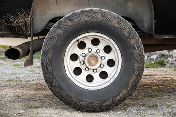 Fototapeta na wymiar Car wheel on dirty rural road, front view