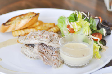 pork steak with vegetable salad and French fries