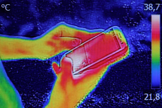 Infrared image showing the heat emission when Young girl used sm