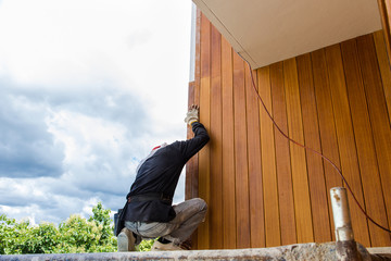 Men build siding Fiber Cement Board on wall exterior