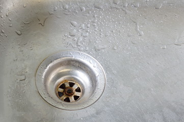 drop of water on silver stainless sink hole