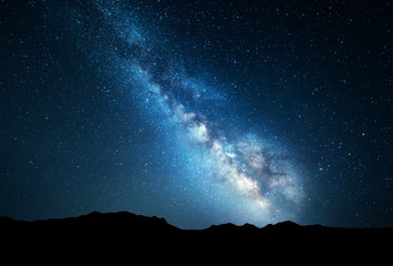 Night landscape with colorful Milky Way at mountains. Starry sky with rocks at summer. Beautiful Universe