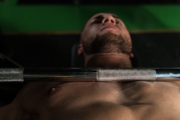 Fototapeta na wymiar Muscular Man Doing Bench Press Exercise For Chest