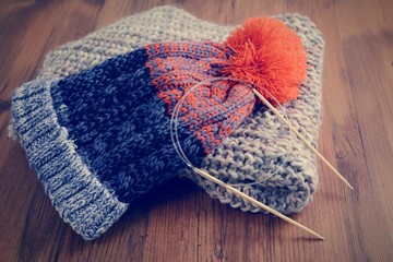 knitting needles with wooly hat. winter cloth handemade