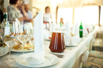 Rolls of white serviettes stand on the dinner plates