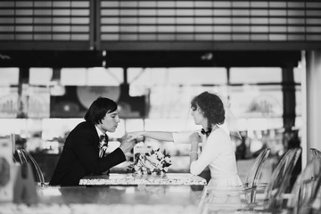 Black and white picture of a groom looking at bride's hand with