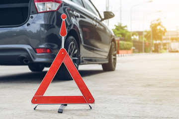 Broken car sign on a road with a broken down car