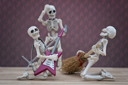 Skeleton playing broom as guitar