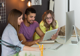 Young start up team looking at digital tablet