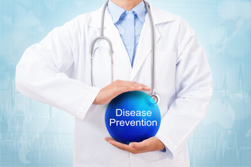 Doctor holding blue crystal ball with disease prevention sign on medical background.