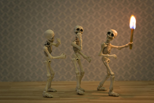 Scarry skeletons in dark place with a torch