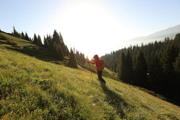 young woman backpacker hiking on beautiful mountain peak