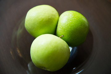 close up of green apples on glass plate