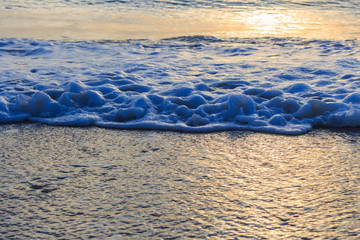 Foamy blue white waves and warm light