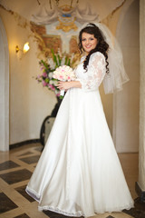 Gorgeous brunette bride poeses in the hotel hall