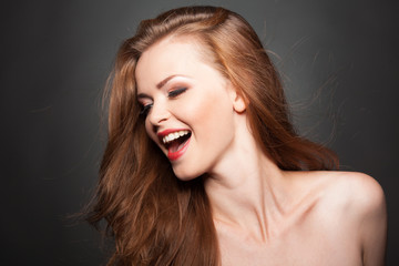 Fototapeta premium Beautiful model with curly brown hair laughs or sings.
