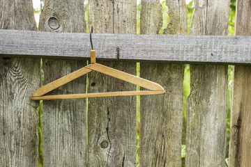 Wooden a hanger hanging on the fence of old outdoors the boards