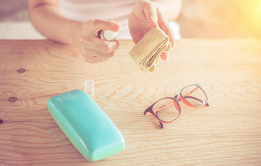 Close up woman hand cleaning glasses by microfiber cloth for cleaning lens and glasses.