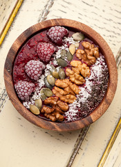 Bowl smoothie with raspberries, chia seeds, pumpkin seeds and nuts