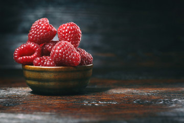 raspberries in bowls on a wooden table