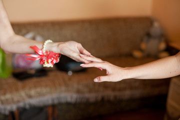 Obraz na płótnie Canvas Woman with rose bracelet holds bride's hand