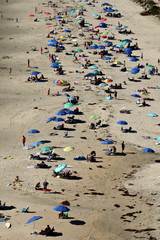 Beach from above with many umbrellas and people taken in southern California. 