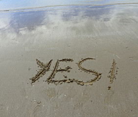 YES written on the beach sand