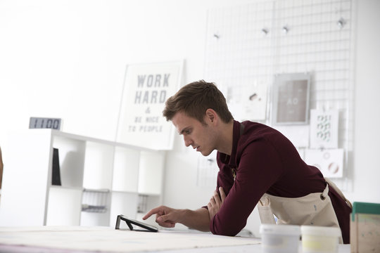 Man Working In Screen Printing Business Using Digital Tablet
