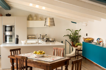 White and steel modern design open plan kitchen with turquoise accent color breakfront and wooden farm style table
