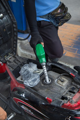 Fuel nozzle add fuel in car at gas station
