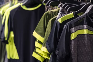 Schließen Sie oben von den Männer-Sport-T-Shirts, die an der Schiene hängen © photoprime